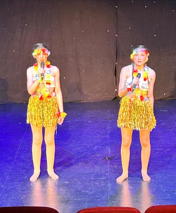 Group of children performing jazz routine in bright costumes
